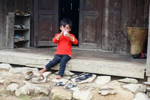 木造の小屋のステップで小さな子供が座っています。 — ストック写真