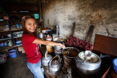 Girl cooking Burmese food in Falam, Myanmar clipart