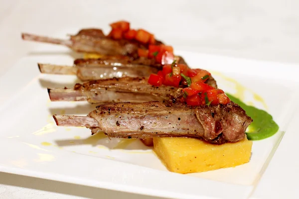 Grilled ribs with polenta on white plate — Stock Photo, Image