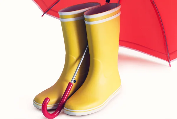 Żółte kalosze i otwarty parasol czerwony — Zdjęcie stockowe