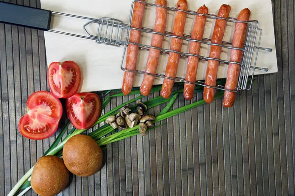 Grelha para salsichas e tomate, pão, cebola, champinhons — Fotografia de Stock