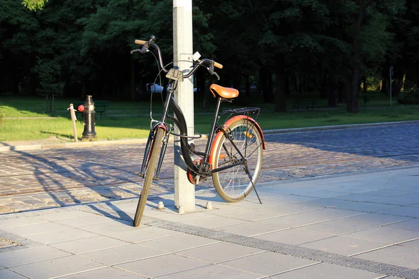 Fahrrad an einem Kabel an einer Säule befestigt — Stockfoto