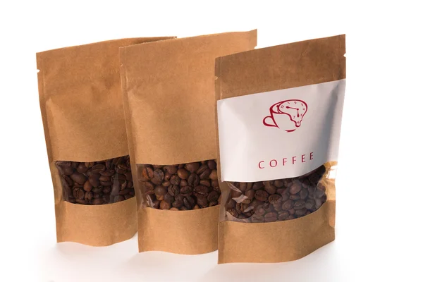 Коричневый кофе зерна в три пакета бумаги — стоковое фото