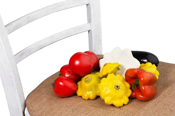 Legumes diferentes em uma cadeira branca de pano de saco — Fotografia de Stock