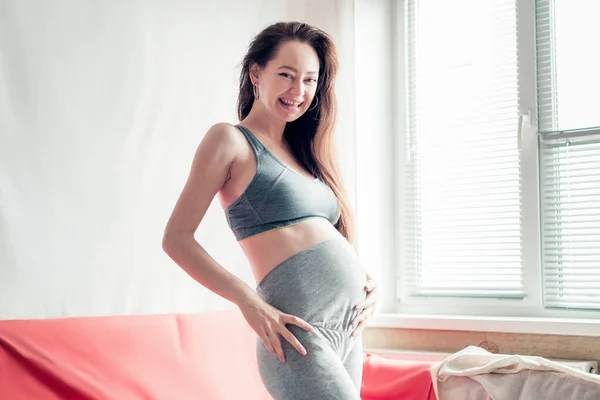 Gravid Flicka Skrattar Och Håller Magen Med Kopieringsutrymme Bakgrund — Stockfoto