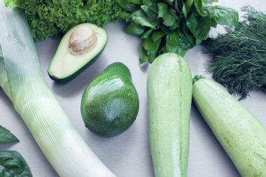 Arka plan olarak avokado, kabak ve yeşillik.