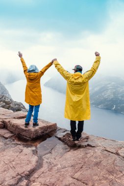 Lysefjord 'un üzerinde ünlü Preikestolen Minpit Rock' ta el ele tutuşan çift duruyor.