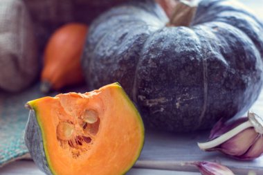 Yeşil kabak ve ahşap bir arka plan üzerinde sarımsak ile diğer renkli kabak Dilim