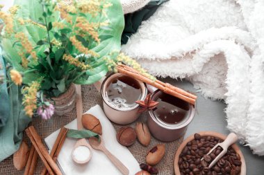 Battaniyenin üzerinde fındık ve tarçınlı iki fincan kahve.