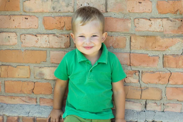 Little boy near a brick wall — Stock Photo, Image