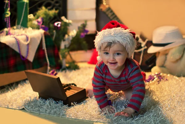 The child in Santa hat crawling on the carpet — Stock Photo, Image