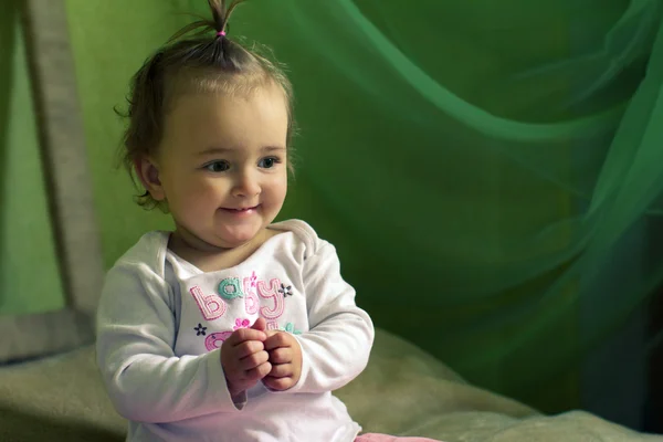 Smiling girl sitting on the bed — Stock Photo, Image