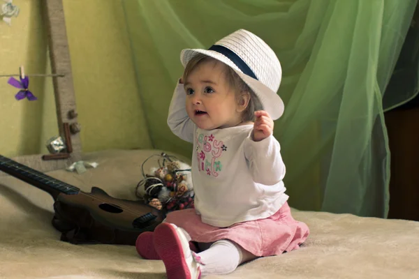 Baby girl with guitar on the bed — Stock Photo, Image