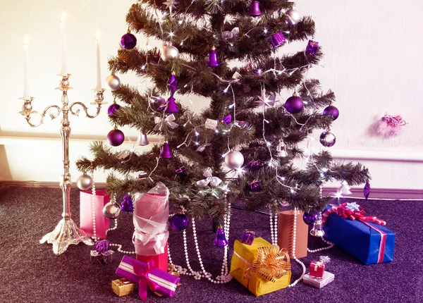 Geschmückter Weihnachtsbaum mit Geschenken rund um und mit dem beleuchteten — Stockfoto