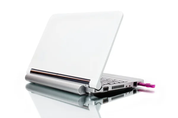 Белый нетбук и розовый ключ USB с отраженной тенью — стоковое фото