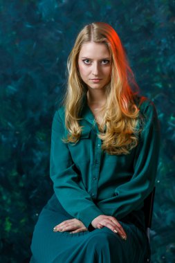 yeşil bir arka planda uzun yeşil elbiseli sarışın kız