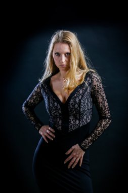 siyah bir arka plan koyu guipure elbiseli sarışın kız