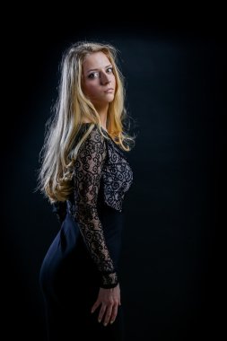 siyah bir arka plan koyu guipure elbiseli sarışın kız