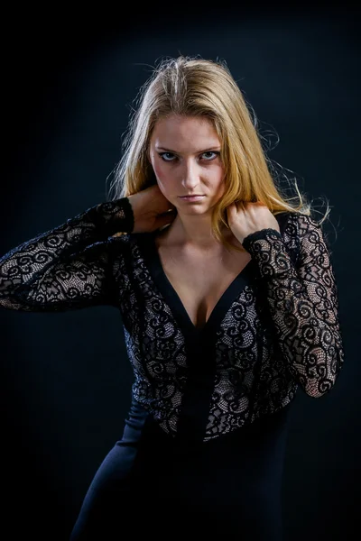 Fille blonde sur un fond noir dans une robe de guipure sombre — Photo