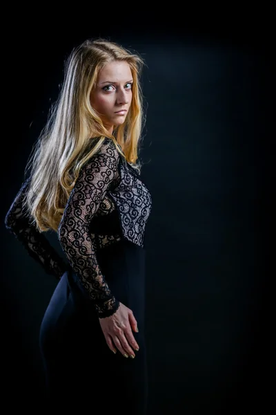 Blonde girl on a black background in a dark guipure dress — Stock Photo, Image