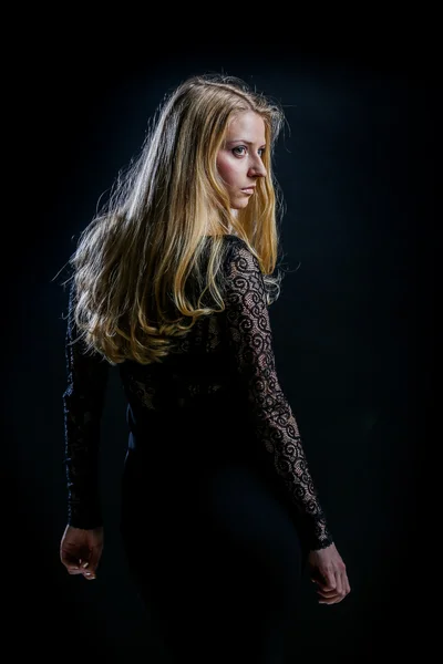 Fille blonde sur un fond noir dans une robe de guipure sombre — Photo