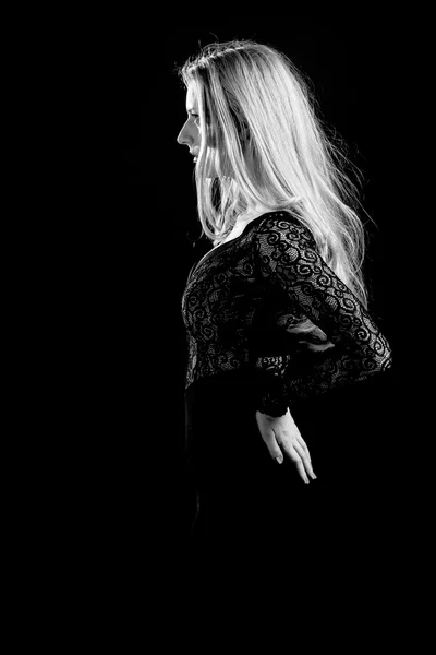 Блондинка на чорному тлі в темній гіпюровій сукні — стокове фото