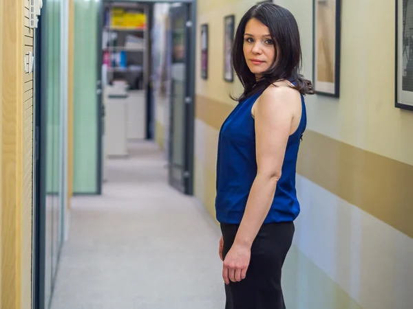 Menina russa bonita posando no corredor do escritório contra a parede — Fotografia de Stock