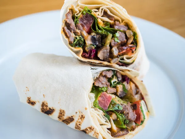 Semmeln im Fladenbrot mit gebratenem Fleisch, Tomaten und Kräutern — Stockfoto