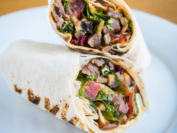 Rolls in pita bread with roasted meat, tomatoes and herbs — Stock Photo, Image