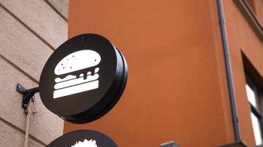 Camların arkasındaki duvarda yuvarlak siyah burger işareti var.