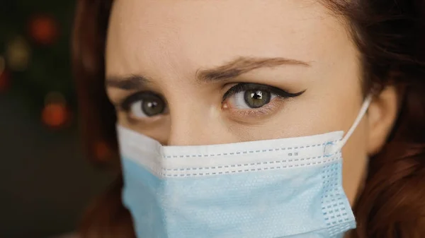Visão macro olho: jovem cansada em máscara facial médica olha para você — Fotografia de Stock