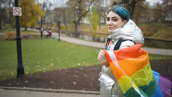 Verde cabello lesbiana mujer caminando con gran arco iris bandera —  Fotos de Stock