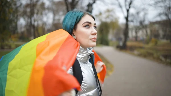 Mujer LGBT caminando con gran bandera de arco iris —  Fotos de Stock