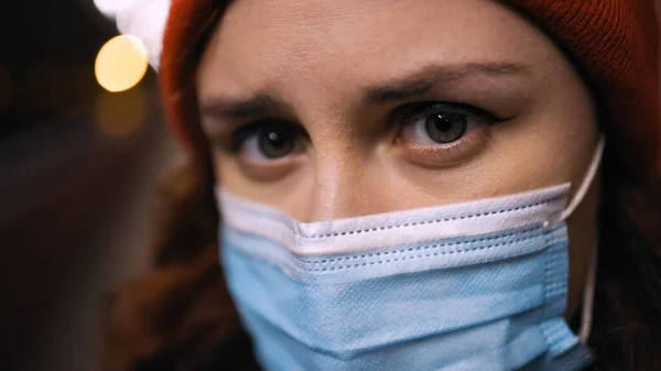 Macro view : Une jeune femme déprimée avec un masque médical vous regarde — Photo