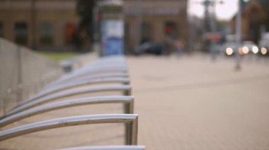 Woman parks electric scooter at bicycle parking