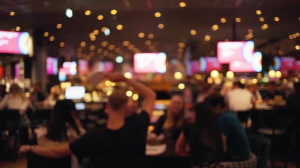 Группа людей, сидящих и болтающих за столом после окончания изоляции в баре или пабе — стоковое видео