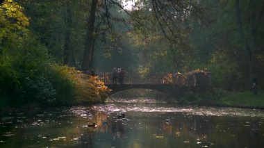 WARsaw, POLAND - 25 Ekim 2020: Lazienki Park 'taki küçük köprüde yürüyen tanımlanamayan turistler. Lazienki Varşova 'daki en büyük parktır..