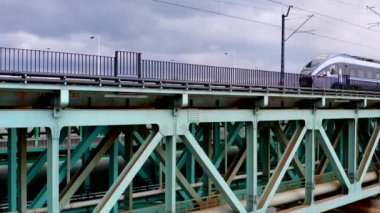 Kış zamanı bulutlu bir günde Varşova 'daki Gdanski Köprüsü' nden tren yaklaşıyor.