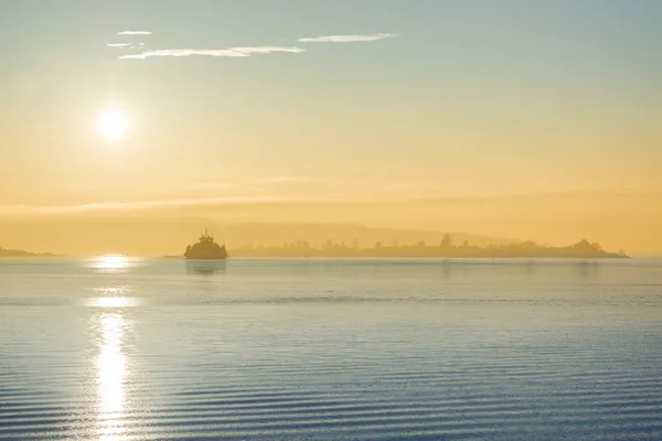 Nákladní loď při západu slunce v moři — Stock fotografie