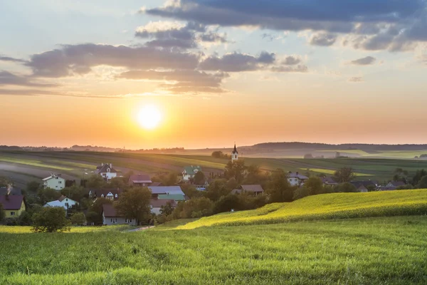 Západ slunce nad vesnicí na polském venkově — Stock fotografie