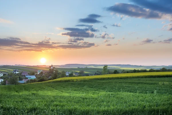 Atardecer sobre pueblo en campo polaco — Foto de Stock