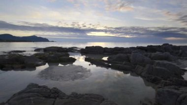 Gün batımından bir kumsalda Lofoten adalar üzerinde