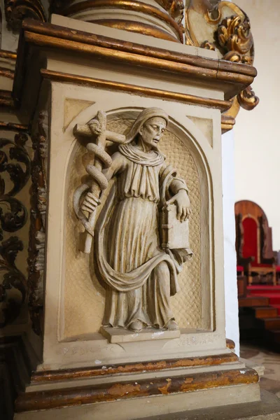 Статуя святого, держащего крест со змеем, задрапированным вокруг него — стоковое фото