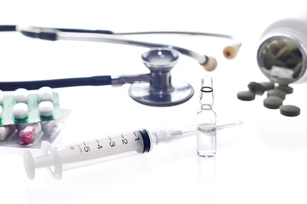 Medische apparatuur: stimulatiedosis van de stethoscoop en injectiespuit op witte achtergrond — Stockfoto