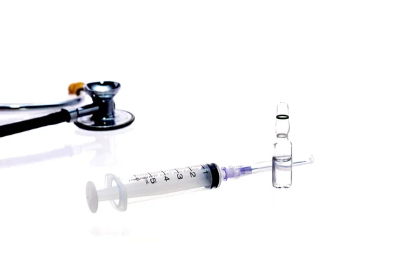 Медичне обладнання: стетоскоп ампули та шприц на білому тлі — стокове фото