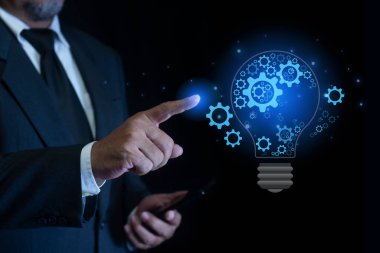 İş adamı, yenilik ve ilham ile yeni fikir kavramı için ampul ve teçhizata dokunuyor. Yenilikçi teknoloji..