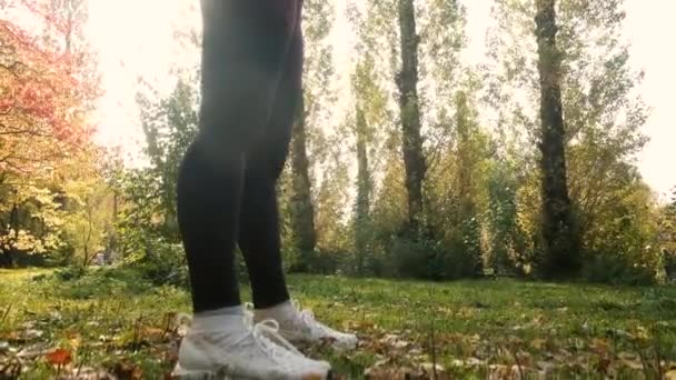Beautiful girl is engaged in gymnastics in the park. Fitness in the autumn forest, calmness and mindfulness, meditation, flexible body. active lifestyle concept. preparing for the beach season — Stock Video