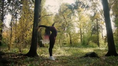 Yoga ustası parkta yoga yapıyor, sakinlik ve farkındalık, meditasyon, jimnastik esnek vücut, arka planda altın güneş ışığı