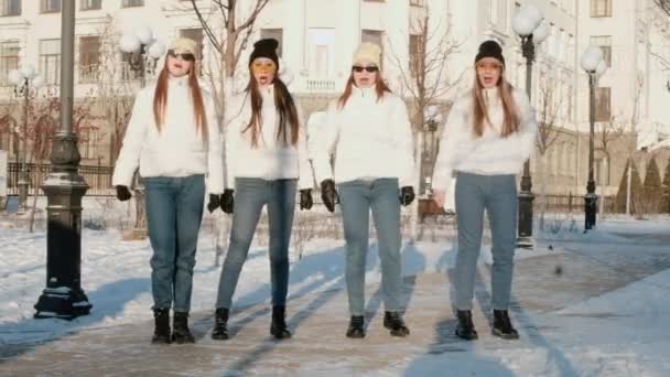 Grupo de quatro mulheres rindo animado correndo em torno de jogar catch-up, brincando, se divertindo em um dia nevado no parque. Dança Esportes Inverno Amizade Conceito Encontro Amigos — Vídeo de Stock