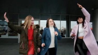 Güler yüzlü bayan arkadaşlar şehirde kendi portresini yapmak için cep telefonu kullanıyorlar. Kızlar oynaşıyor, eğleniyor, temiz havada yürüyor. Arkadaşlarla buluşacağız. İletişim. 25-30 yaşlarında.